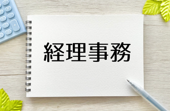 “経理事務”と書かれたノートとペン